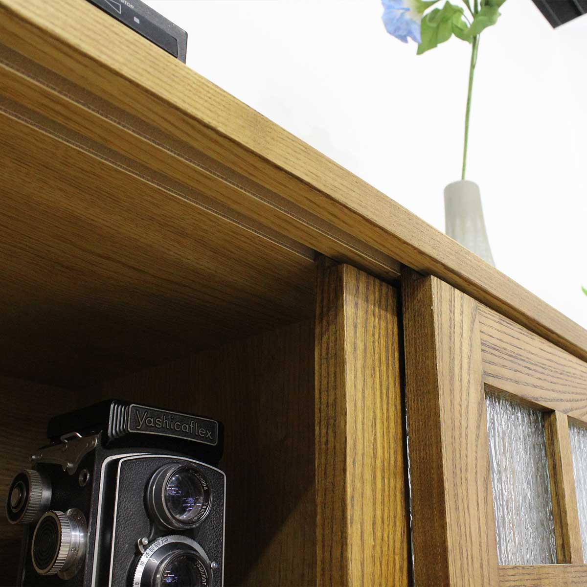 120センチ幅（幅120）キャビネット「アミコ」アッシュ材は扉は引戸で、扉は引戸で、左右の格子のデザインを非対称（アシンメトリー）にする事により、<br>
アンバランスで、オシャレでかっこいい印象のデザインにとなっています。